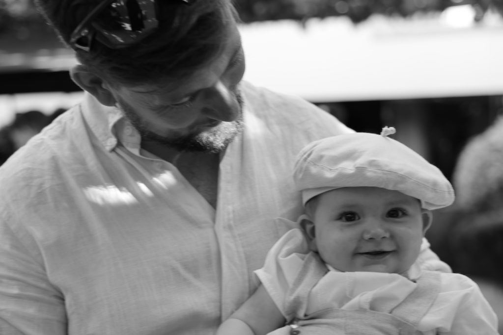 un bébé au mariage tenu dans les bras de son père